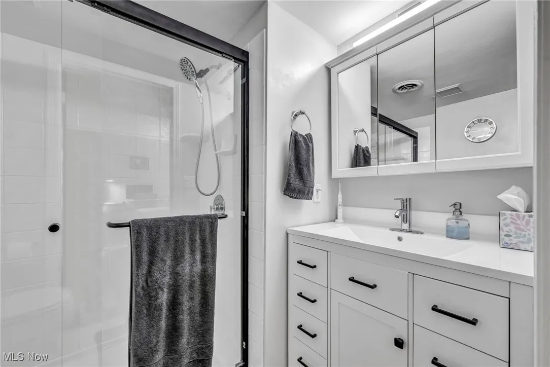 Full bath featuring a shower stall and vanity