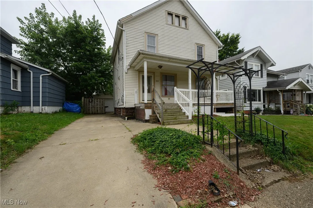 View of front of home with covered porch and a front lawn