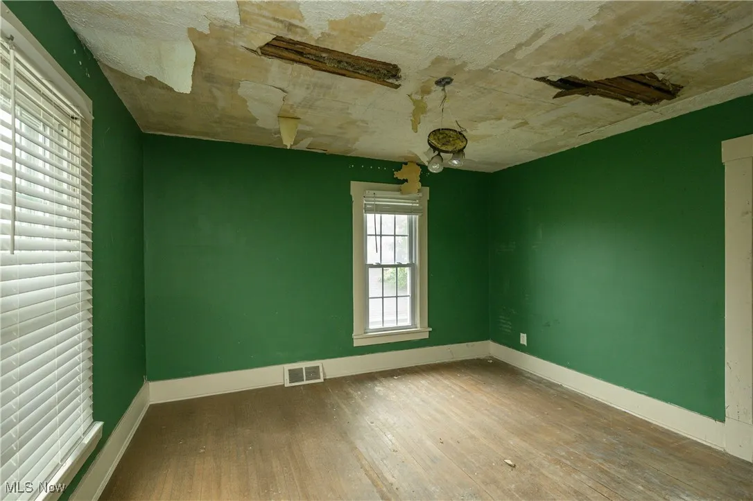 Spare room with hardwood / wood-style flooring and baseboards