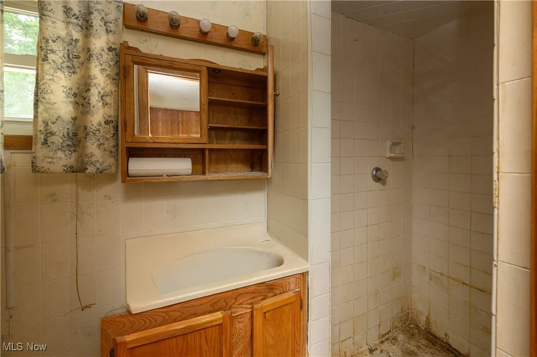 Full bathroom featuring a tile shower and vanity