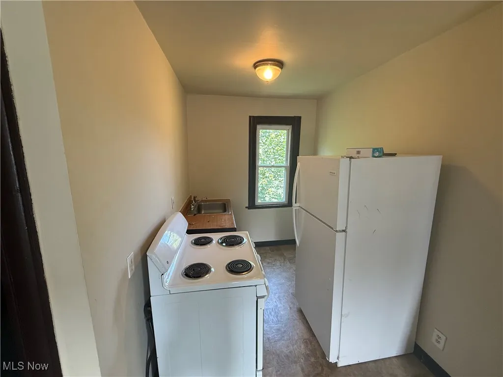 Kitchen featuring white appliances and a sink