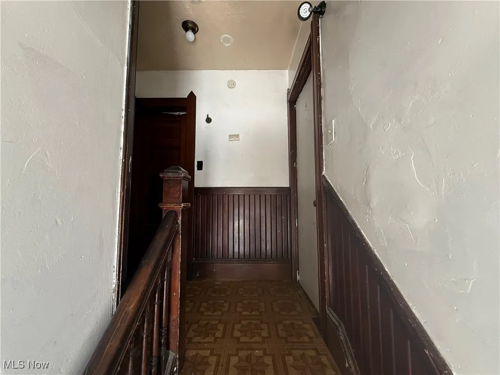 Hall featuring dark floors and an upstairs landing
