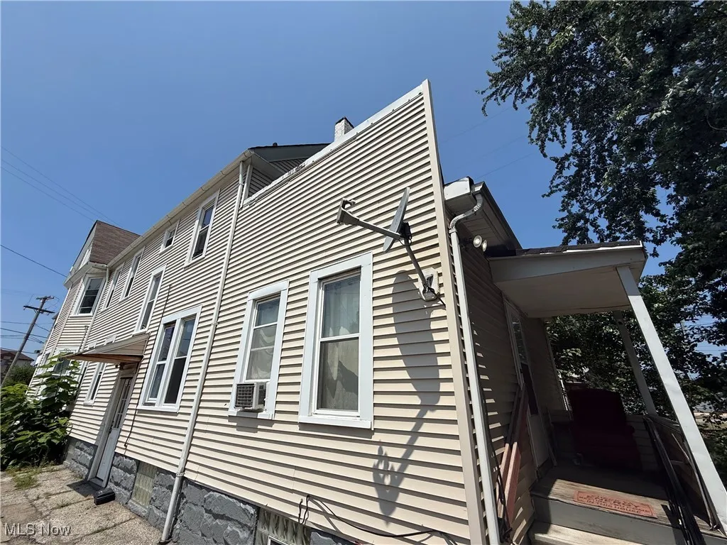 View of home's exterior with cooling unit and a chimney