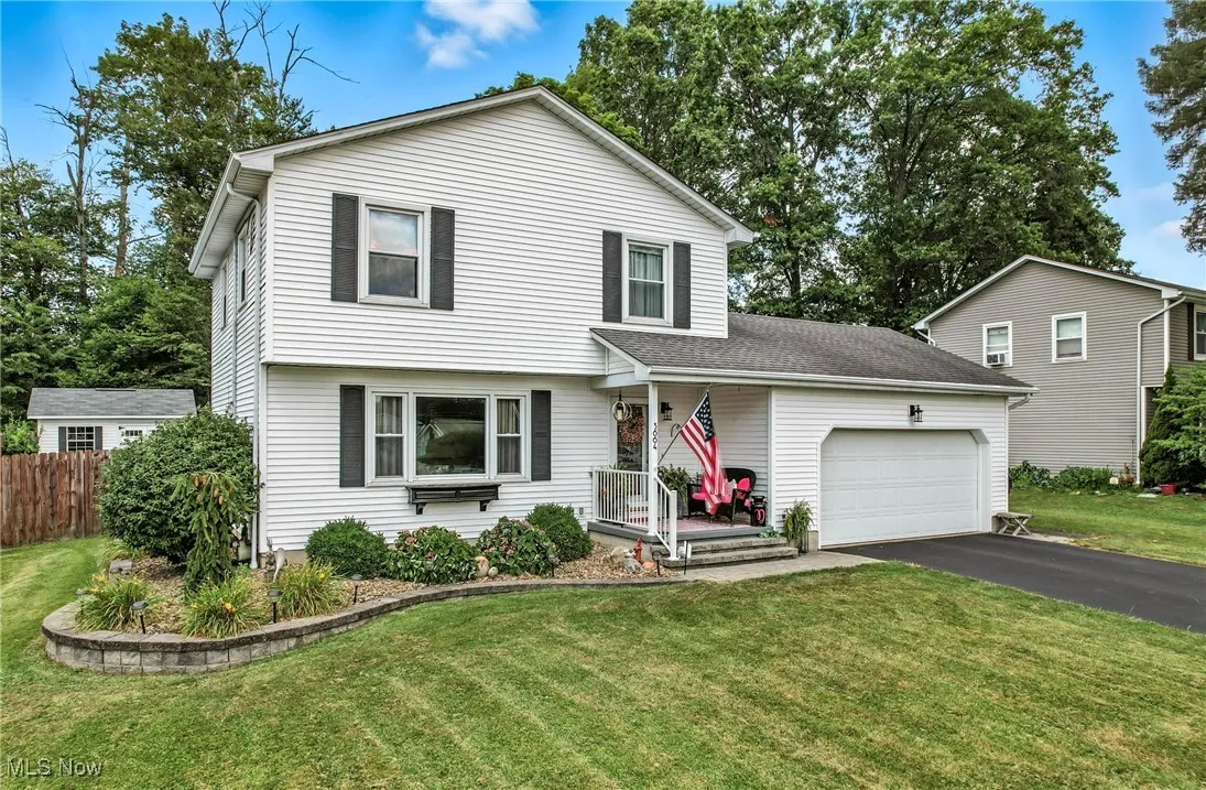 View of front of property with a garage, driveway, and covered porch