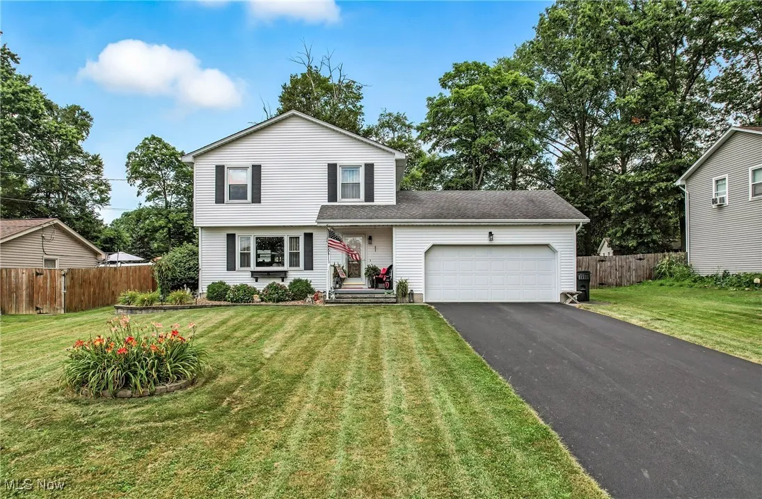 View of front of house featuring new asphalt driveway and an attached garage