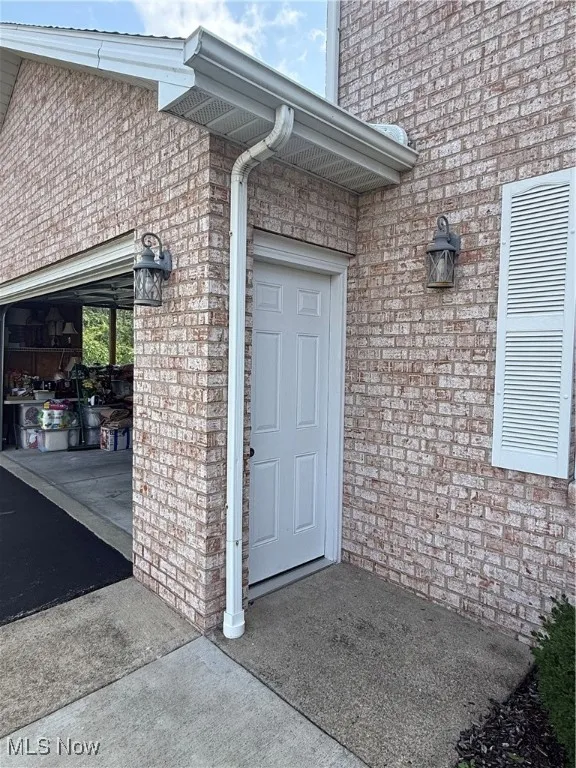 Property entrance featuring brick siding
