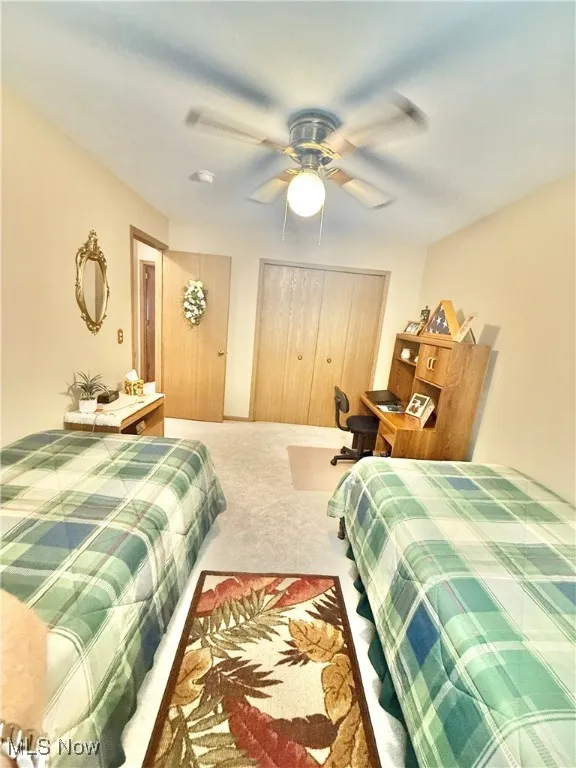 Bedroom featuring carpet flooring, a closet, and a ceiling fan