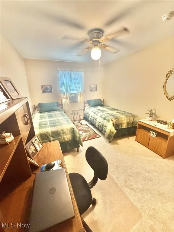 Carpeted bedroom with a ceiling fan