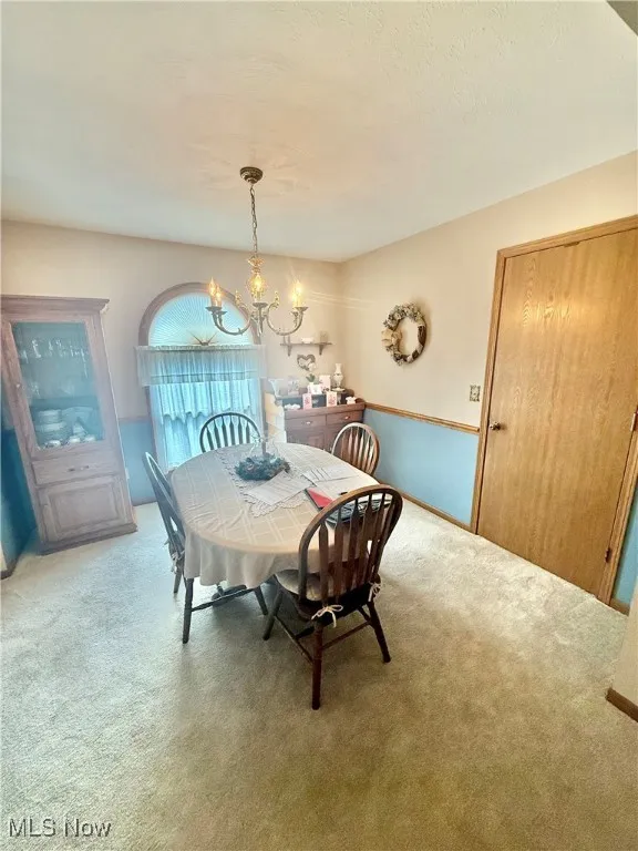 Dining space featuring a chandelier and carpet floors