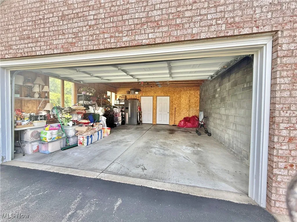 Garage with stainless steel refrigerator with ice dispenser