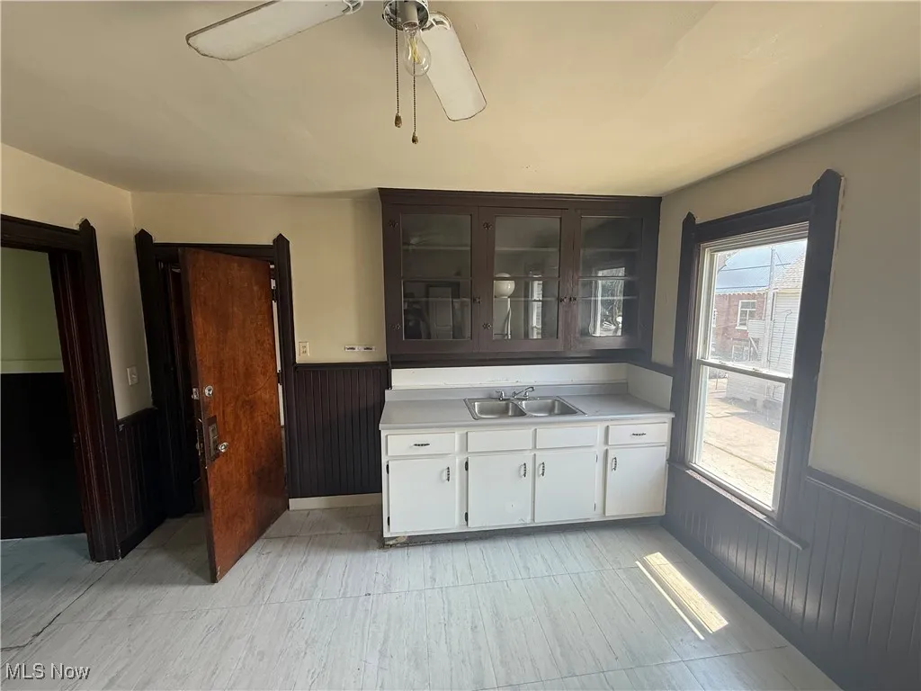 Bar area featuring a wainscoted wall and ceiling fan