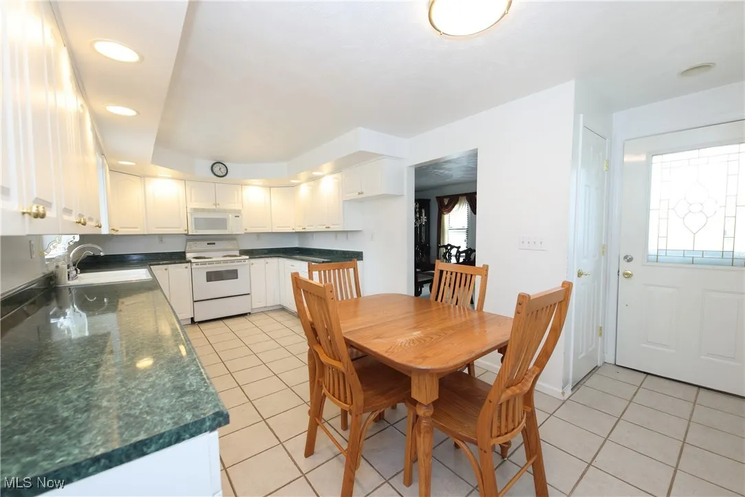 Dining area with light tile patterned floors, plenty of natural light, and recessed lighting