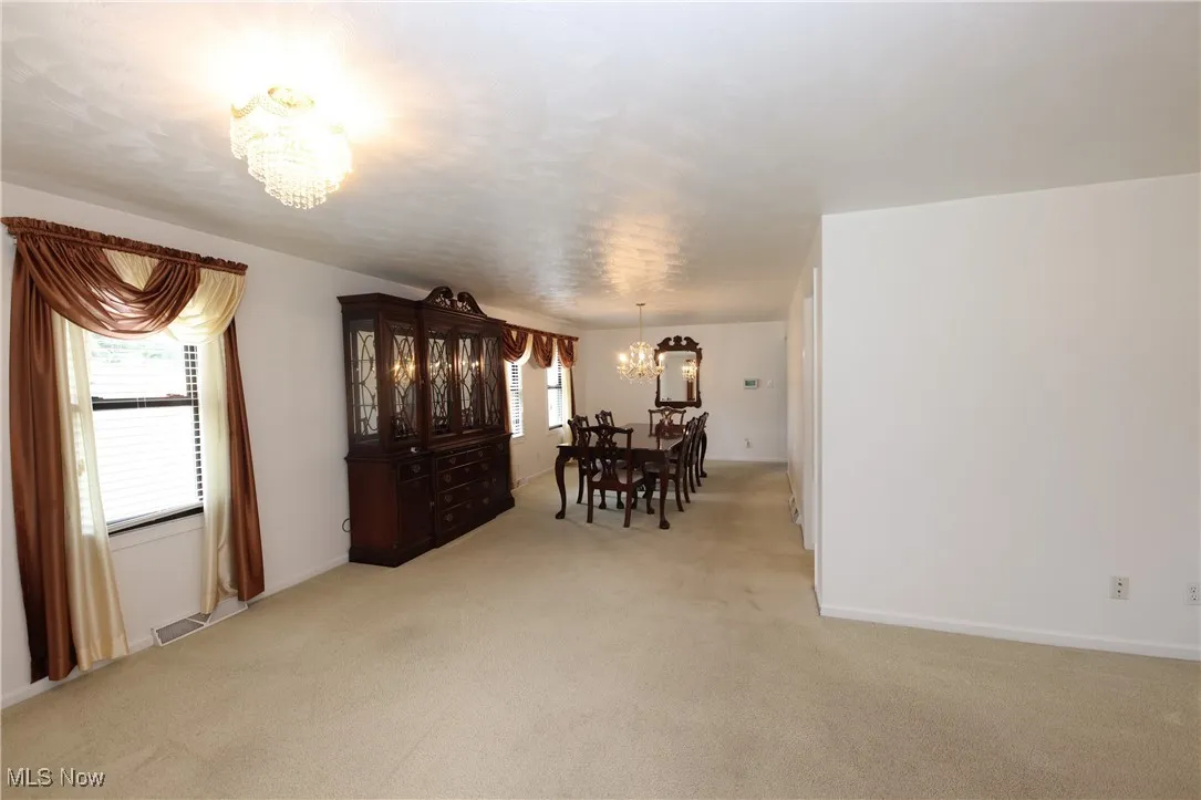 Dining space with a chandelier and light carpet