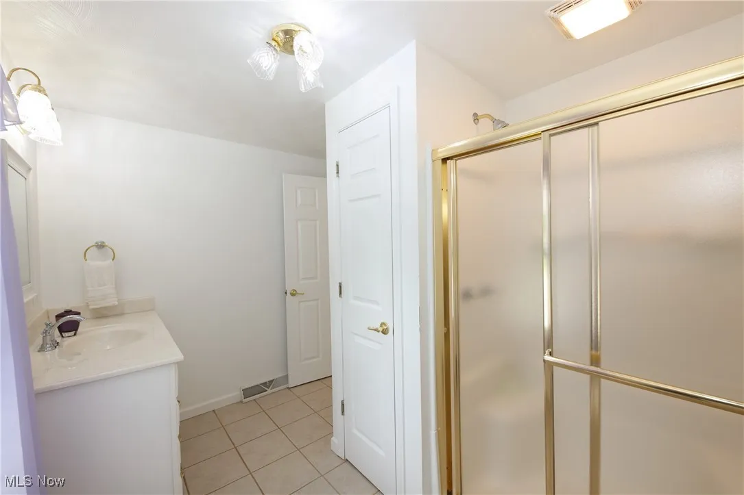 Bathroom featuring vanity, a stall shower, and tile patterned floors