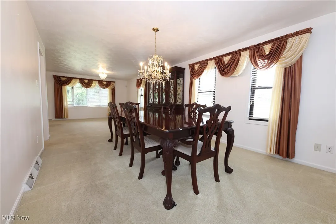 Dining area featuring a chandelier and light carpet