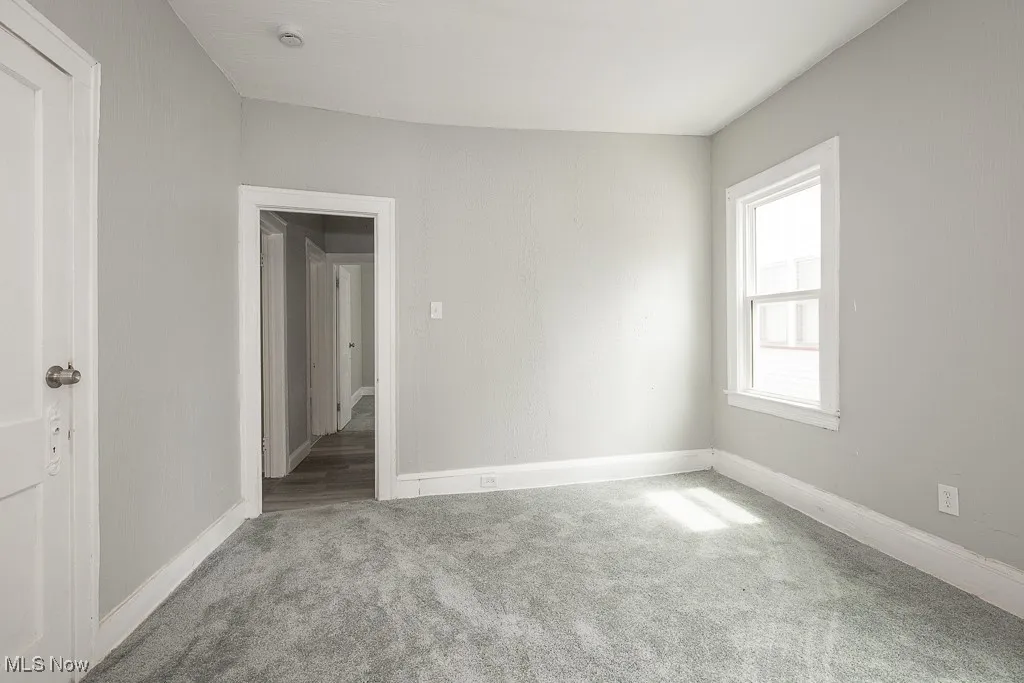 Carpeted spare room with baseboards