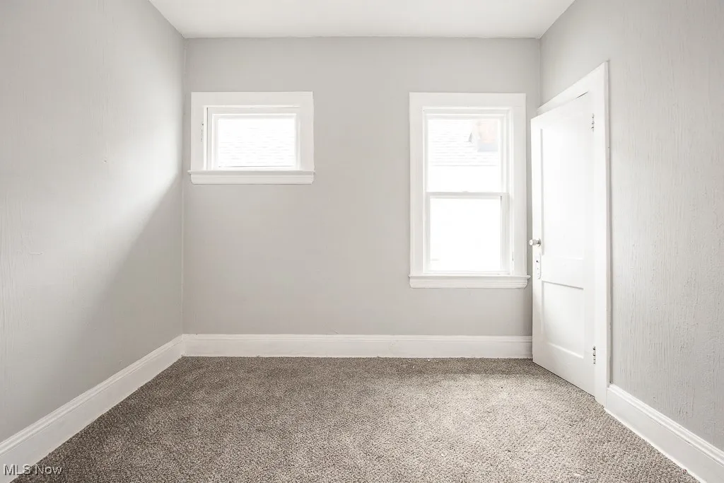 Carpeted empty room featuring baseboards
