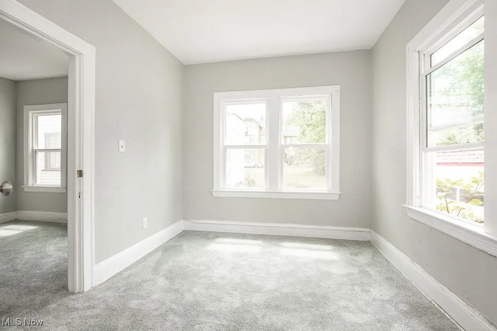 Carpeted empty room featuring healthy amount of natural light