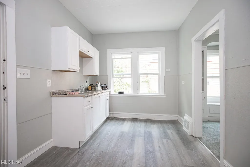 Kitchen featuring wood finished floors and white cabinetry