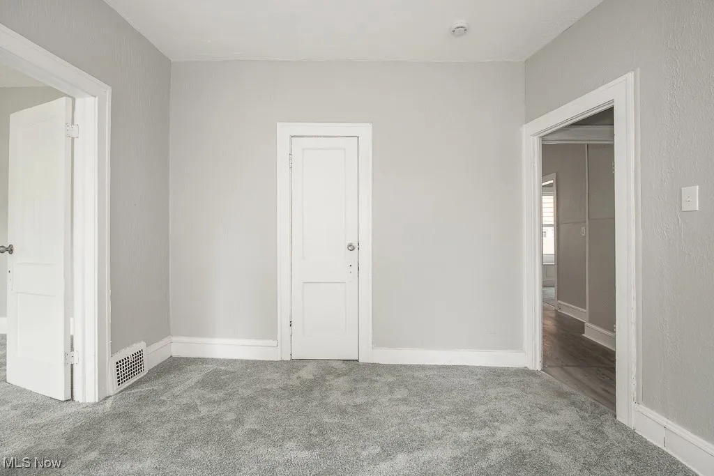 Spare room with a smoke detector and carpet floors