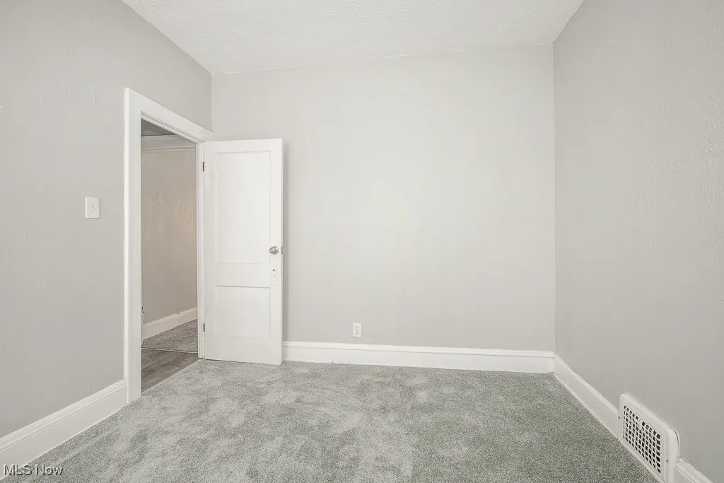 Unfurnished room with carpet floors and baseboards