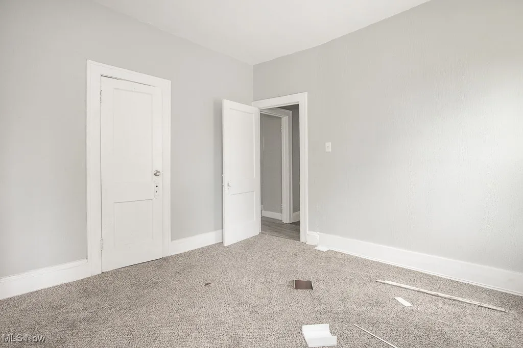 Carpeted spare room with baseboards
