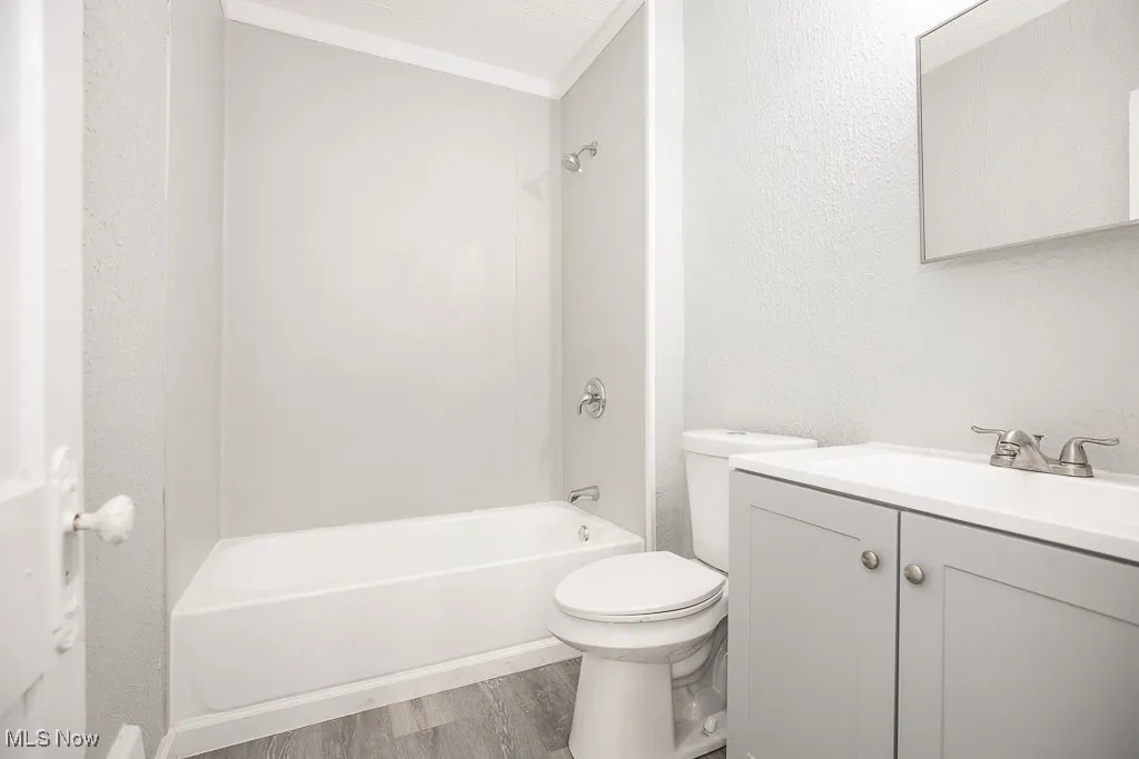 Full bathroom featuring vanity, wood finished floors, and shower / tub combination