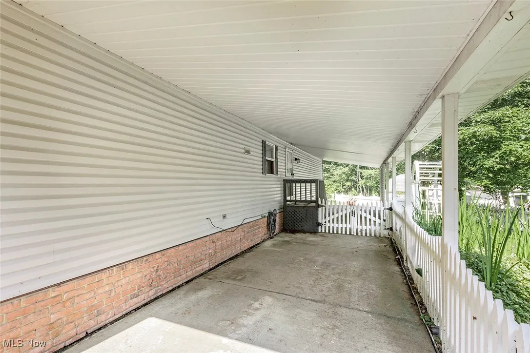 View of patio with a carport and a gate