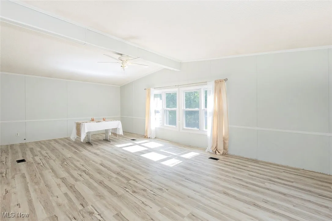 Spare room with wood finished floors and a ceiling fan