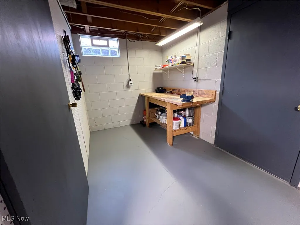 Below grade area featuring a workshop area and concrete block wall