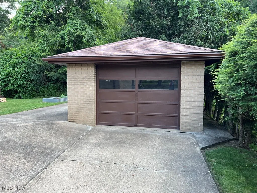 Detached garage featuring concrete driveway
