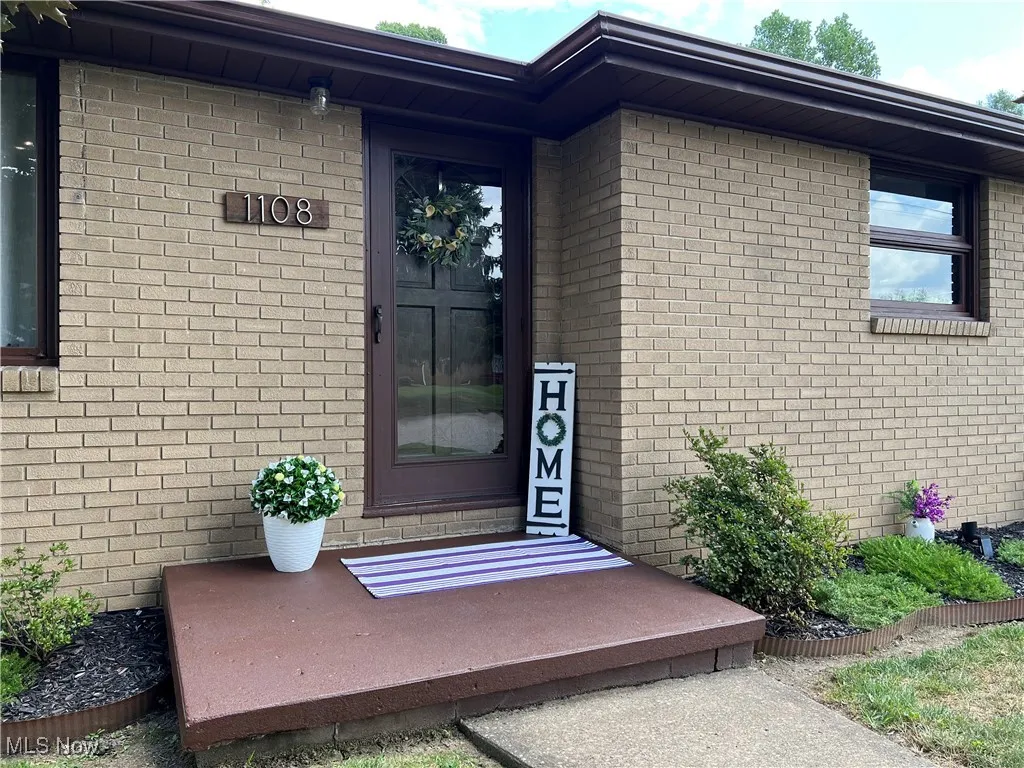 View of exterior entry featuring brick siding
