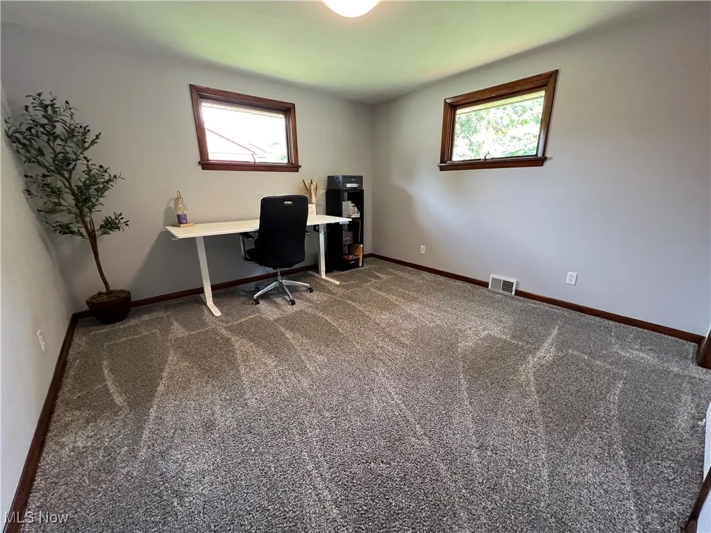 Carpeted home office with healthy amount of natural light