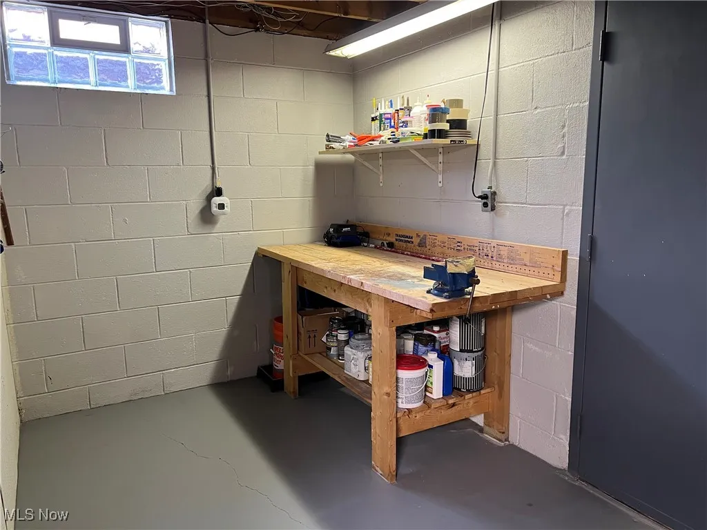 Below grade area featuring a workshop area and concrete block wall