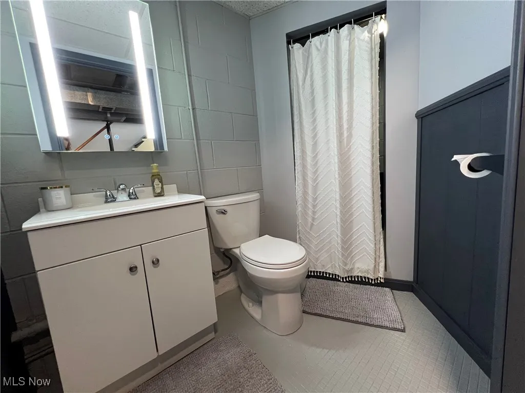 Full bathroom featuring vanity, tile patterned flooring, and a shower with curtain