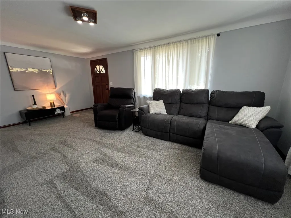 Carpeted living room with baseboards