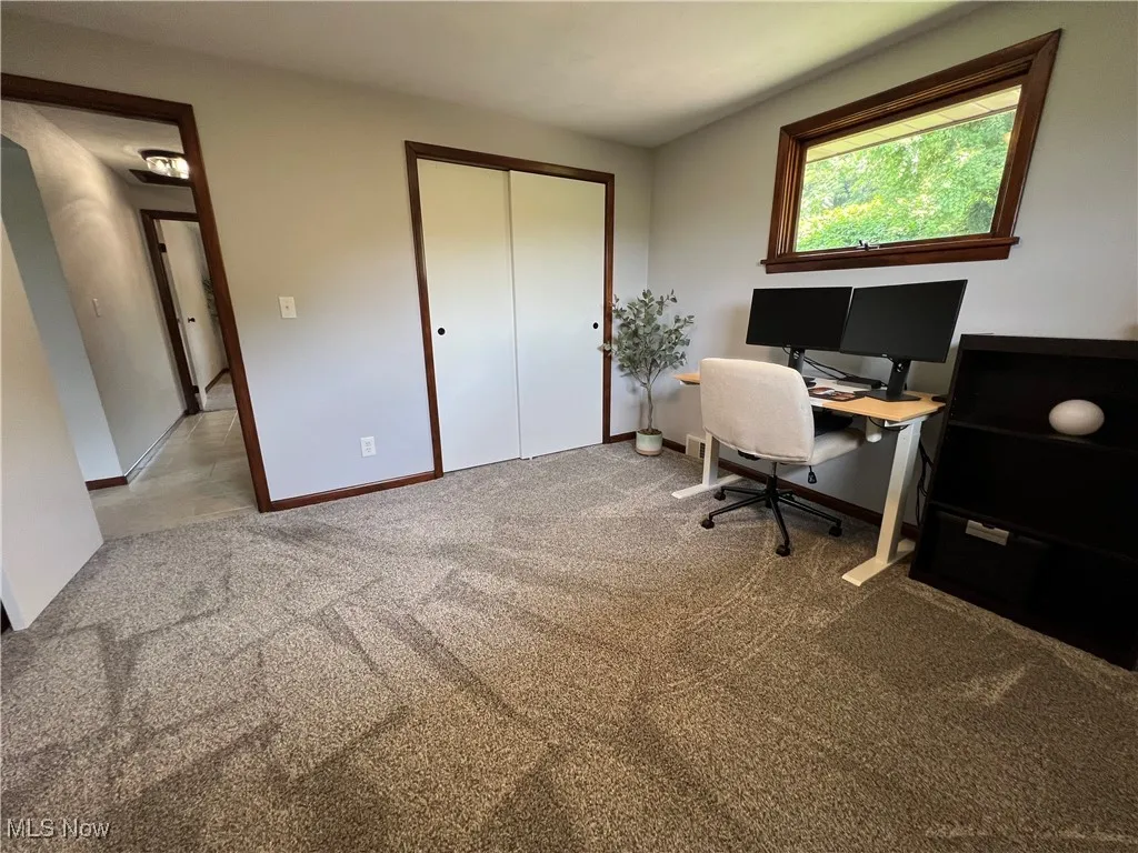 Home office featuring carpet flooring and baseboards