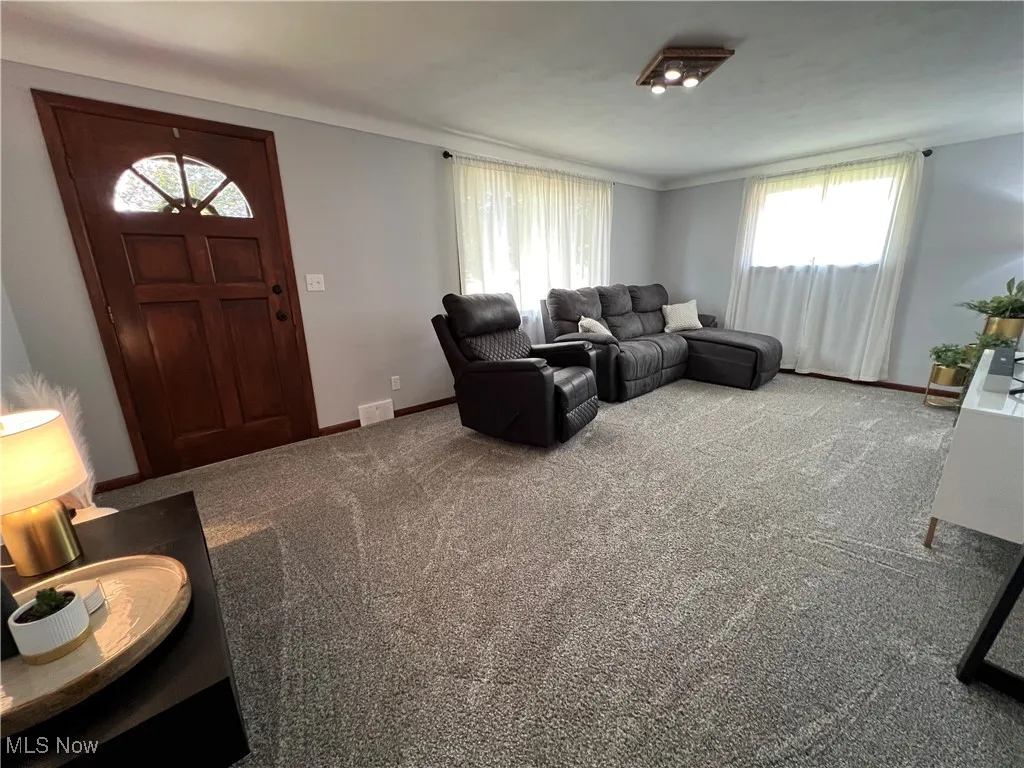 Living area with carpet flooring and baseboards