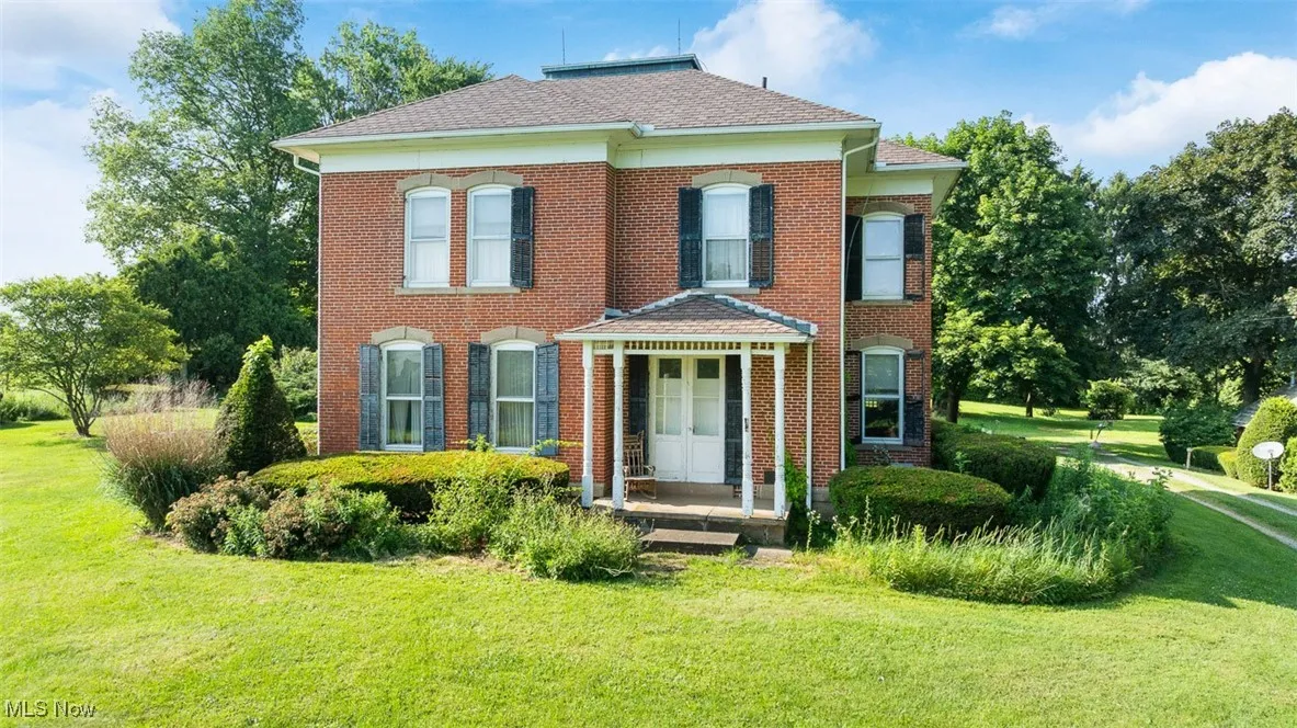 View of front of house with a front lawn, brick siding, and a shingled roof