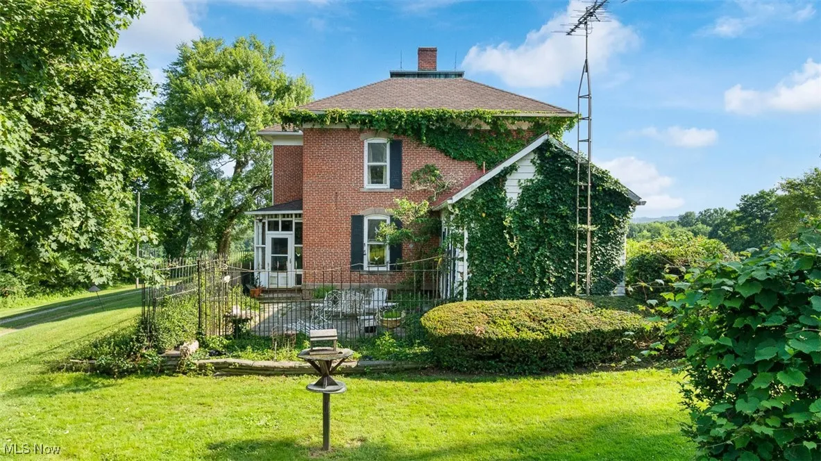 View of property exterior with brick siding and a chimney