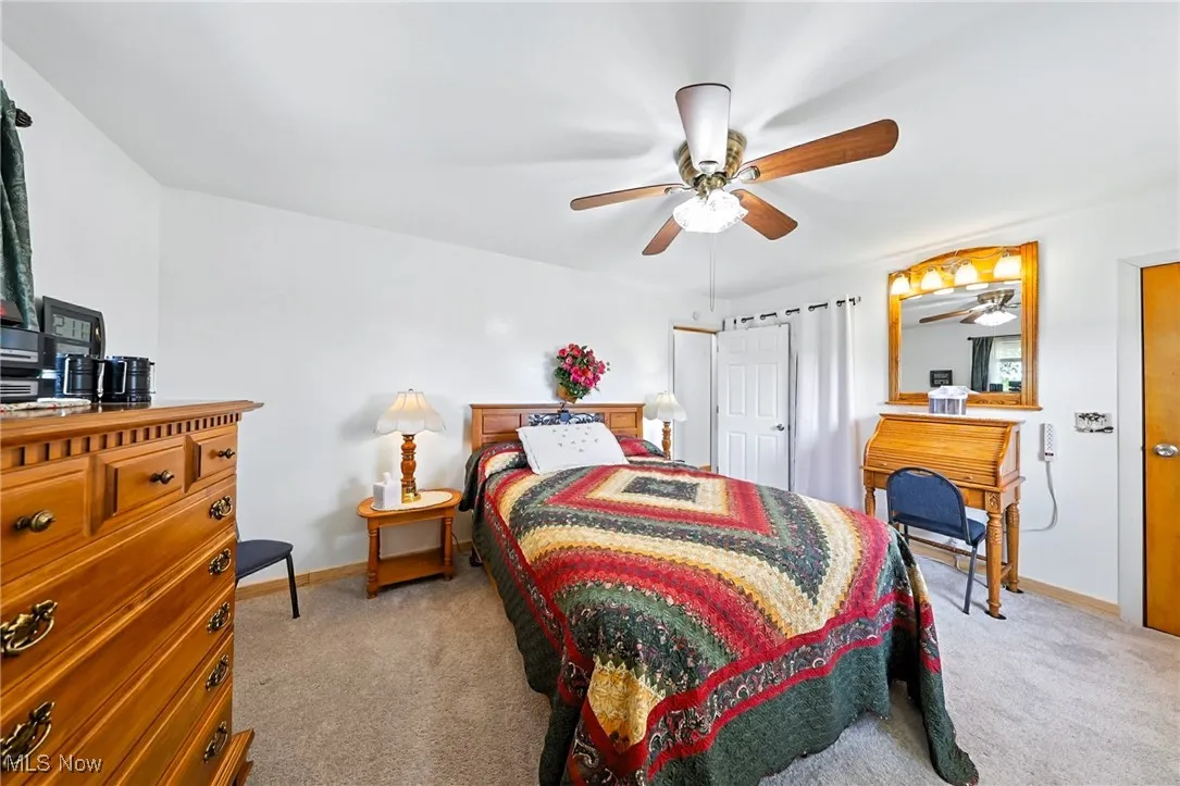 Bedroom with light colored carpet and ceiling fan