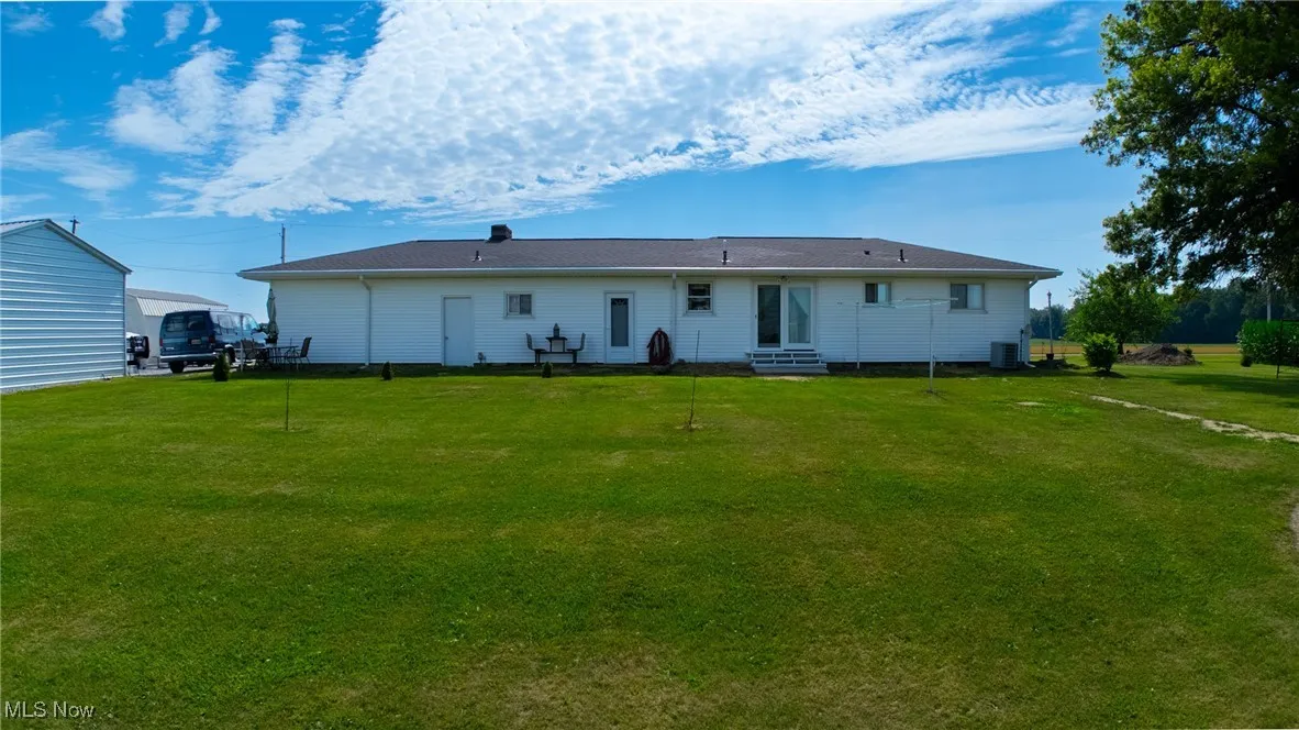 Back of house with a yard