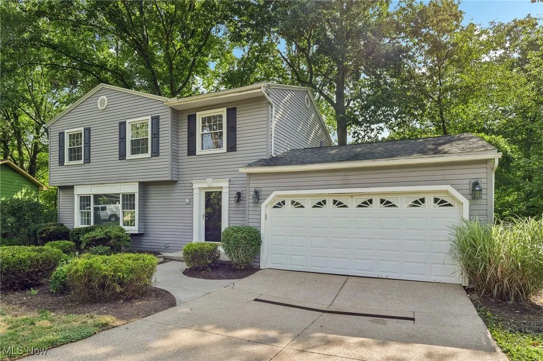 View of front of property with driveway and an attached garage