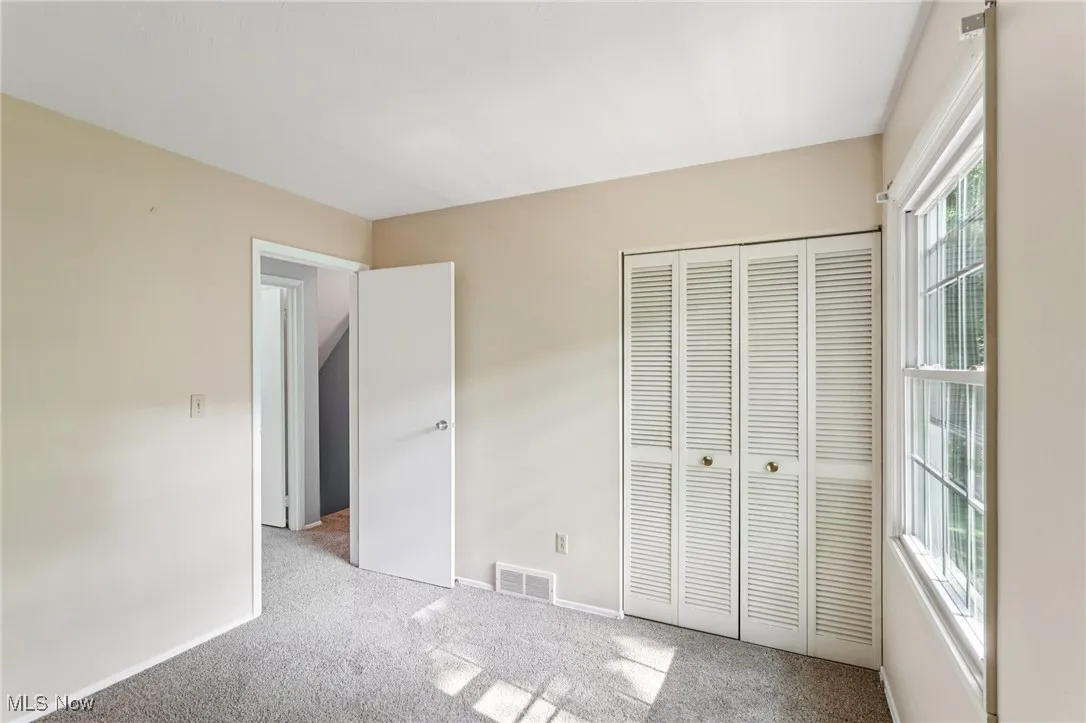 Unfurnished bedroom with carpet flooring and a closet
