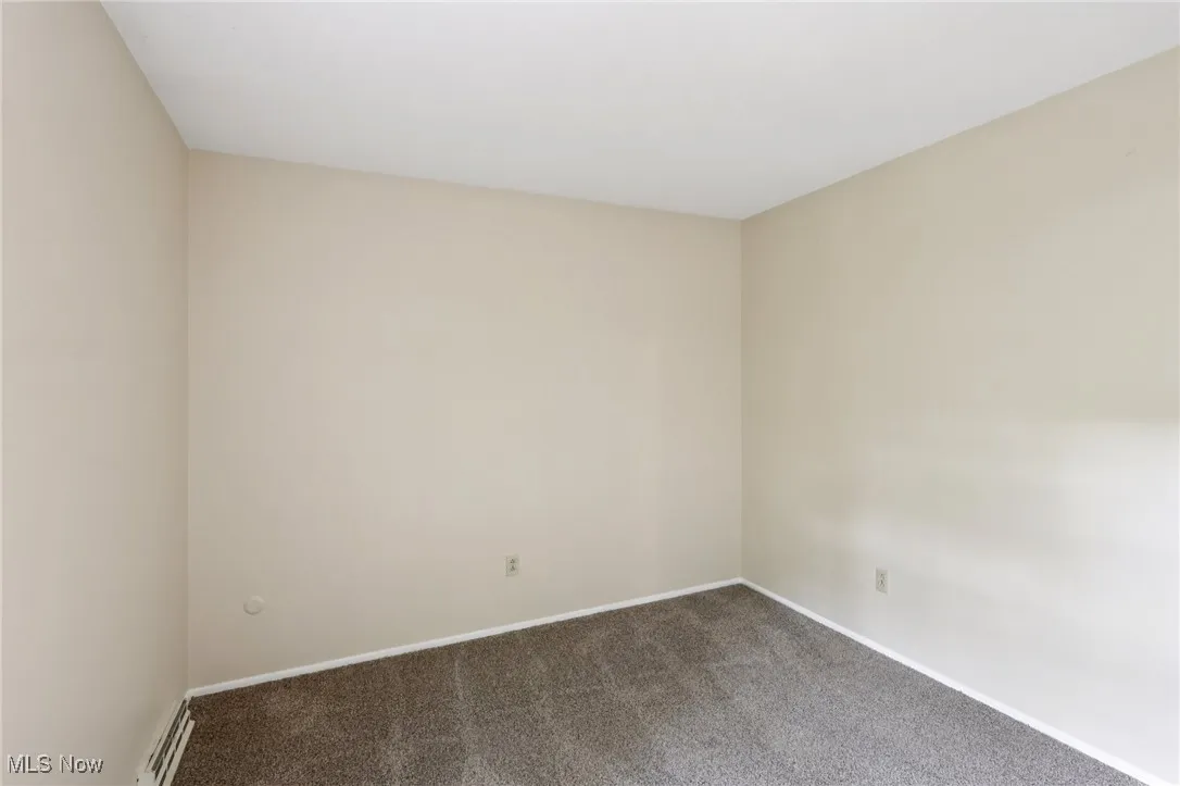 Empty room featuring carpet flooring and baseboards