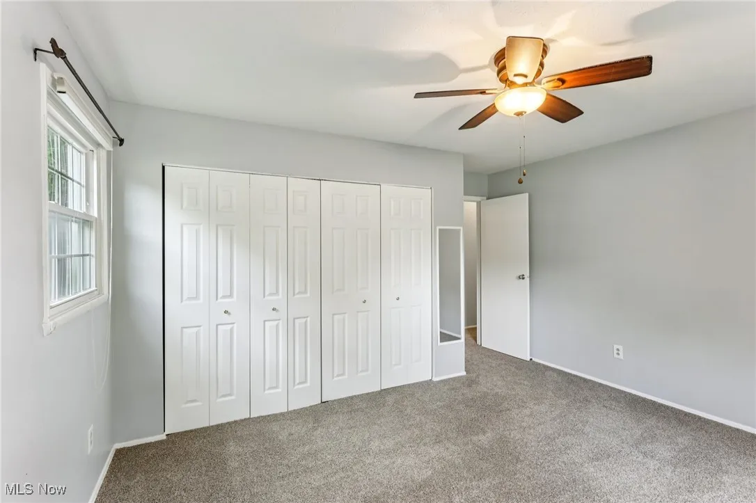 Unfurnished bedroom with carpet flooring, a closet, and ceiling fan