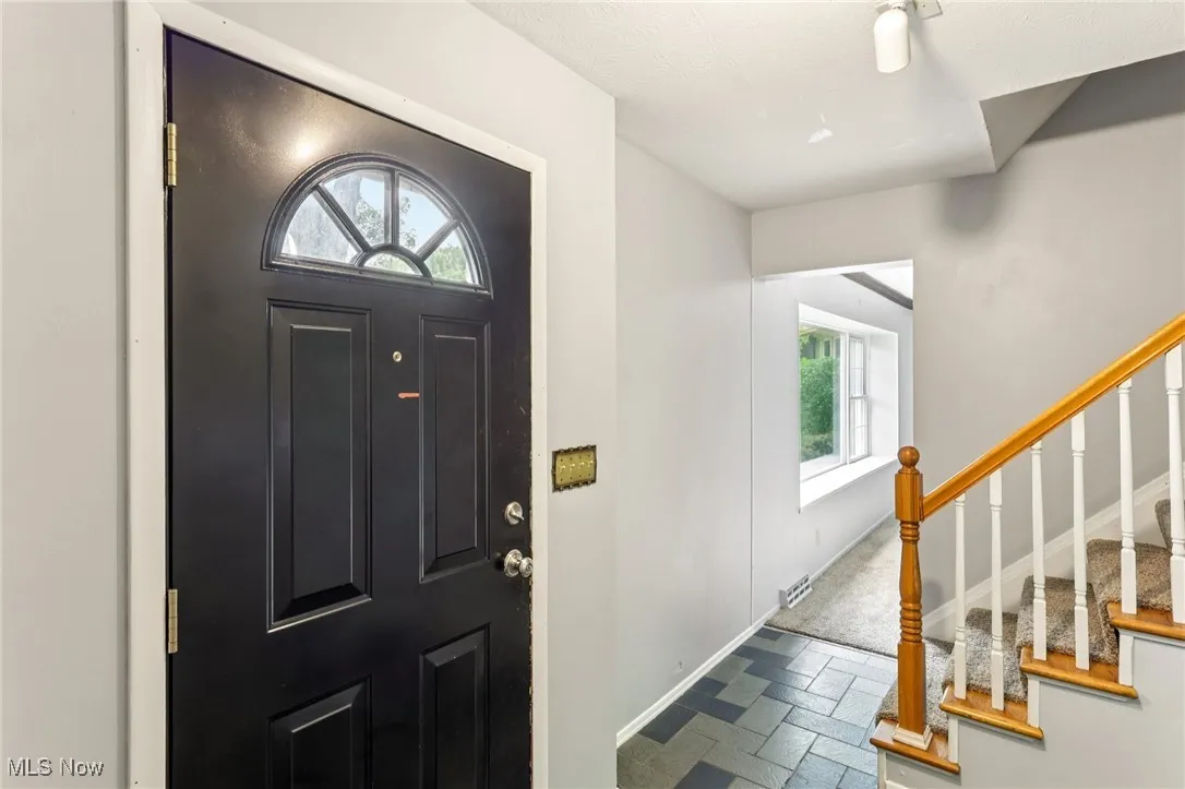 Foyer with stairway and stone tile floors