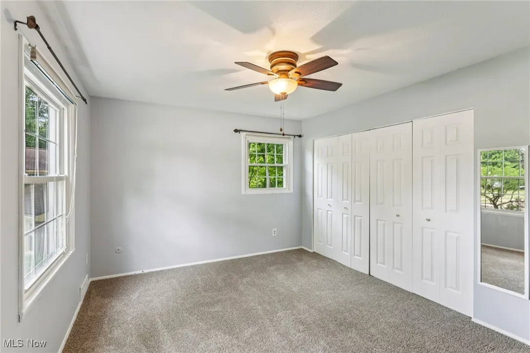 Unfurnished bedroom featuring carpet flooring, a closet, and ceiling fan