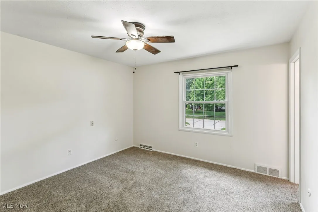 Spare room featuring ceiling fan and carpet