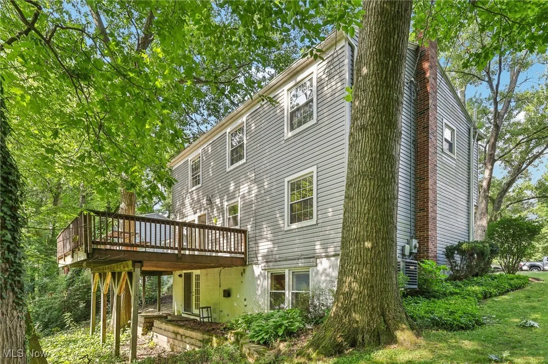 Back of house with a deck and a chimney